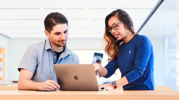 nhân viên tại Apple Store hướng dẫn khách hàng làm quen với Macbook